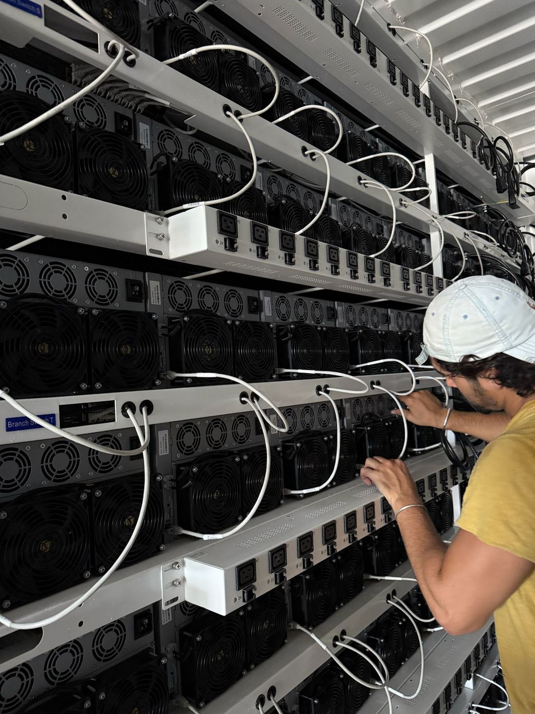 Crew working on miners inside a container
